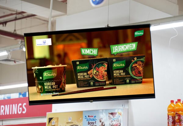 Digital screen in a retail store showcasing Knorr Korean Meal Pot advertisement with Kimchi and Jjajangmyeon flavors.