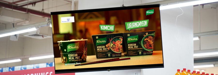 Digital screen in a retail store showcasing Knorr Korean Meal Pot advertisement with Kimchi and Jjajangmyeon flavors.