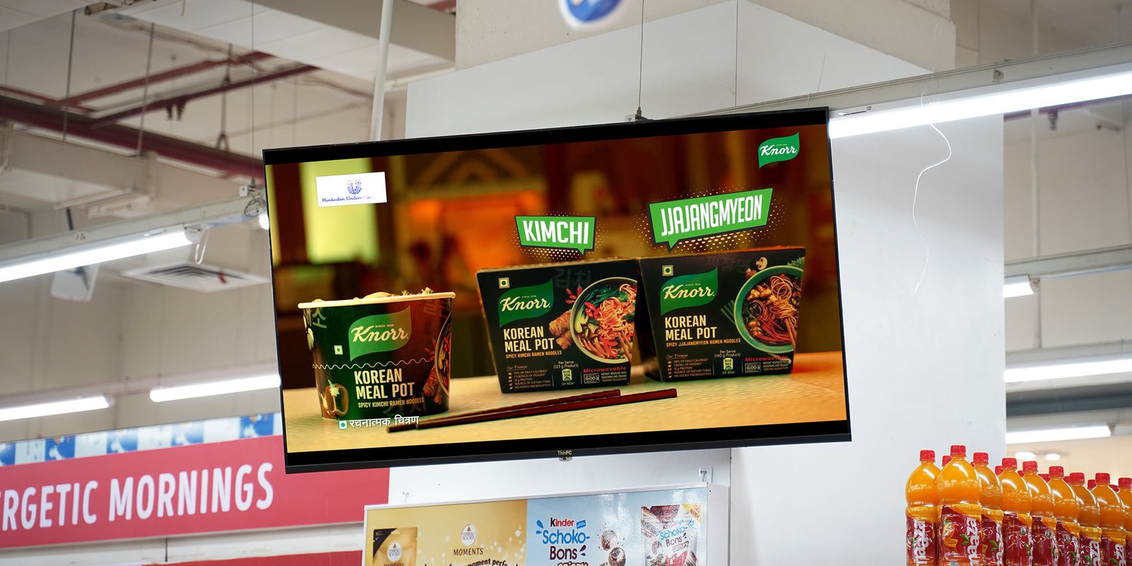 Digital screen in a retail store showcasing Knorr Korean Meal Pot advertisement with Kimchi and Jjajangmyeon flavors.